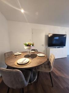 a dining room table with chairs and a television at Winterberg Appartement 21128 in Winterberg