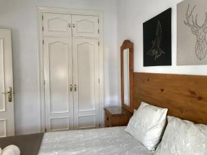 1 dormitorio con cama blanca y armario blanco en Acogedor apartamento en Málaga centro, en Málaga