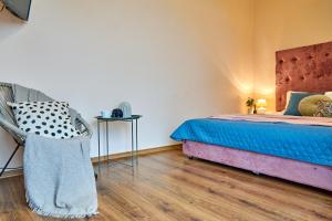 um quarto com uma cama e uma cadeira em Panoramic View Lux Apartment em Mukacheve