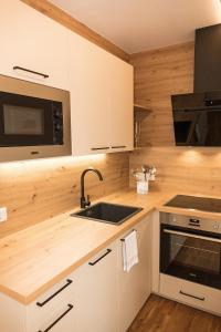 uma cozinha com armários brancos e um lavatório em Appartement Rehlein em Mauterndorf