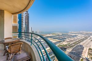 a balcony with a table and chairs and a view of the city at Superhost Sea View Spacious 202 square meters apartment luxury property in Dubai