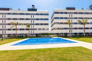 a building with a swimming pool in front of a building at Vivendos Lujoso apartamento de playa in Torremolinos