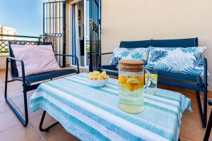 a table with a pitcher and a bowl of fruit on a balcony at Estupendo apartamento junto a magníficas playas in Torremolinos