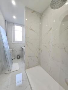 a white bathroom with a shower and a sink at Magnifique Appartement Clichy in Clichy