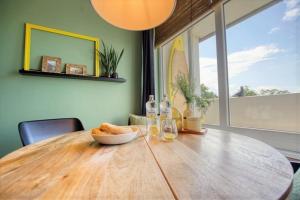 una mesa de madera con un tazón de pan y vasos en Ferienpark - Haus M, App 0MEG08, en Heiligenhafen