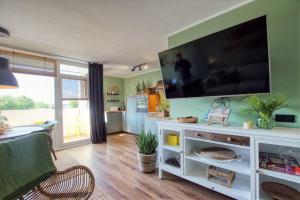 uma sala de estar com uma grande televisão de ecrã plano na parede em Ferienpark - Haus M, App 0MEG08 em Heiligenhafen
