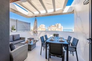 una sala da pranzo con tavolo, sedie e divano di Vivendos - Luxury Duplex with Private pool a Torremolinos