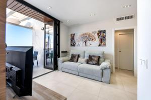 sala de estar con sofá y TV en Vivendos - Luxury Duplex with Private pool, en Torremolinos