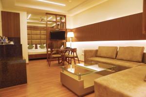 ein Wohnzimmer mit einem Sofa und einem Tisch in der Unterkunft Karon Hotels - Lajpat Nagar in Neu-Delhi