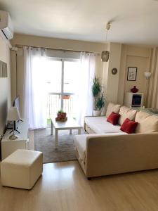 sala de estar con sofá y mesa en Bonito Apartamento en la Macarena en Sevilla