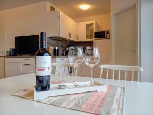 eine Flasche Wein auf einem Tisch mit zwei Weingläsern in der Unterkunft Ferienpark - Haus N, App 0N0502 in Heiligenhafen