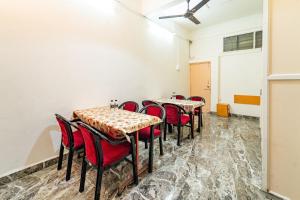 a row of tables in a room with red chairs at Itsy By Treebo - Mansi in Nashik