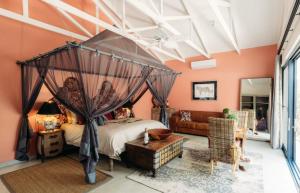 una camera con letto a baldacchino e divano di Safari Moon Luxury Bush Lodge a Hoedspruit
