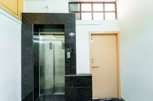 a bathroom with a walk in shower next to a door at Itsy By Treebo - Mansi in Nashik