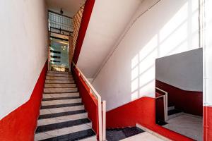 a staircase in a building with red and white walls at Itsy By Treebo - Mansi in Nashik