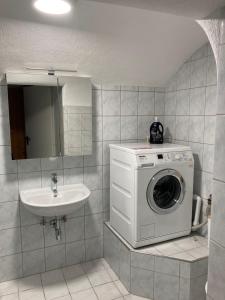 a bathroom with a washing machine and a sink at Familienfreundliches Haus mit eingezäuntem Garten in Biberwier