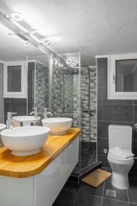 a bathroom with two sinks and a toilet at Simplicity and Comfort: Apartment in Zografou in Athens