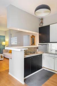 una cocina con electrodomésticos en blanco y negro en una habitación en Simplicity and Comfort: Apartment in Zografou, en Atenas