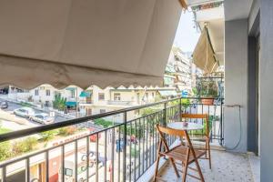 a balcony with two chairs and a table and a street at Simplicity and Comfort: Apartment in Zografou in Athens