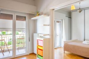 a bedroom with a bed and a view of a balcony at Simplicity and Comfort: Apartment in Zografou in Athens