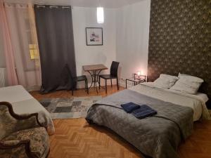 a bedroom with a bed and a chair and a table at Gîte pour professionnels en déplacement - CENTRE VILLE - Parking gratuit in Bellac