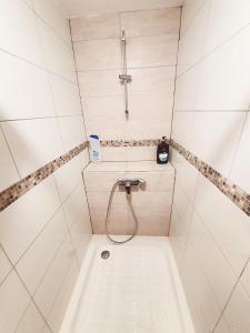La salle de bains est pourvue d'une baignoire et d'une douche. dans l'établissement N 1 - Spacieux T4 - CENTRE VILLE - balcons - 2 SDB - 3 CH- parking gratuit, à Bellac