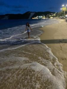 a woman walking in the water on the beach at ACM Flat in Natal