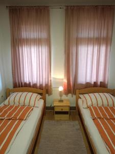 sypialnia z 2 łóżkami i stołem z lampką w obiekcie Apartment and rooms"Tabašnice"Tuzla centar w mieście Tuzla