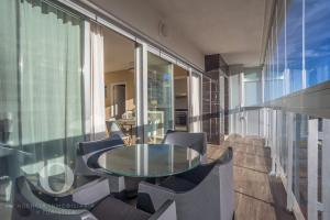 una mesa de cristal y sillas en una habitación en Holiday Deluxe Apartment Miramar Magic World, en Oropesa del Mar
