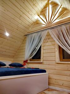 um quarto com uma cama num chalé de madeira em Zymbiańsko Chałupa 2 z jacuzzi em Ząb