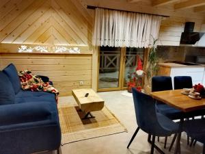 a living room with a blue couch and a table at Zymbiańsko Chałupa 2 z jacuzzi in Ząb