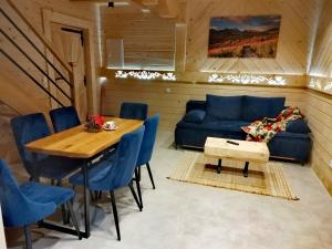 a dining room with a blue couch and a table at Zymbiańsko Chałupa 2 z jacuzzi in Ząb