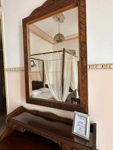 einen Spiegel an der Wand mit einem Bett in einem Zimmer in der Unterkunft monte kristo in Ermoupoli