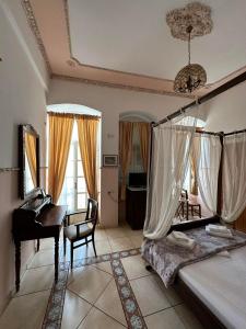 a bedroom with a bed and a desk and a piano at monte kristo in Ermoupoli