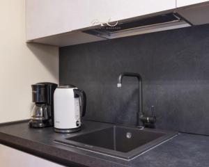 encimera de cocina con fregadero y cafetera en Appartamento Acquaseria 310, en Ponte di Legno