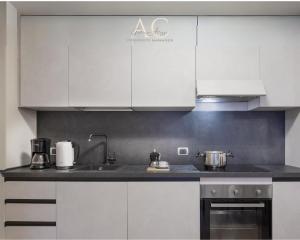 una cocina con armarios blancos y fregadero en Appartamento Acquaseria 310, en Ponte di Legno