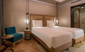sypialnia z dużym łóżkiem i niebieskim krzesłem w obiekcie 10 Karakoy w Stambule
