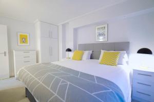 een slaapkamer met een groot bed met gele en blauwe kussens bij Camden Serviced Apartments by Globe Apartments in Londen
