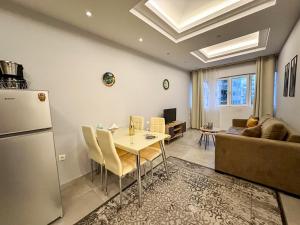 a kitchen and living room with a table and a refrigerator at Contemporary & Spacious Renovated Apartment, DT Syntagma, /Touristic Area in Athens