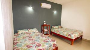a bedroom with two beds and a night stand at Las Palmas in Bacalar