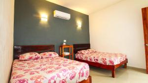 a bedroom with two beds and a air conditioner at Las Palmas in Bacalar