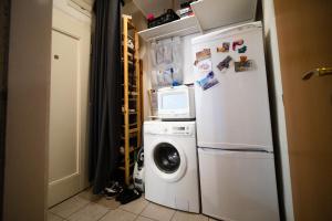 eine Küche mit einer Waschmaschine und einem Kühlschrank in der Unterkunft Klidný a útulný byt in Prag