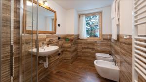 a bathroom with a sink and a toilet and a mirror at Chalet Li Mina in Livigno