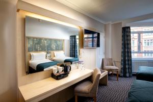 a hotel room with two beds and a mirror at Bedford Hotel in London