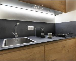 una cocina con fregadero de acero inoxidable y encimera en Appartamento Mirella Wood, en Ponte di Legno