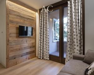 sala de estar con pared de madera y TV de pantalla plana en Appartamento Mirella Wood, en Ponte di Legno