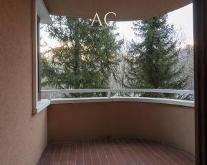 Un balcón con una gran ventana y árboles en Appartamento Mirella Wood, en Ponte di Legno