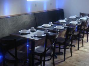 un grupo de mesas y sillas con platos y utensilios en Scotia Airport Hotel, en Paisley