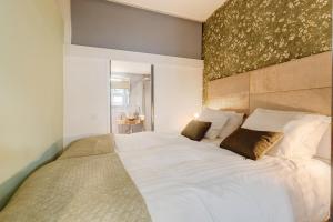 a bedroom with a large bed with white sheets at Beautiful apartment in vibrant Utrecht City Center in Utrecht