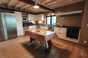 a kitchen with a table with a checkered table cloth on it at Le Grand Cerf 25 pers, Malmedy- Chalet rustique, jardin in Malmedy +21 photos